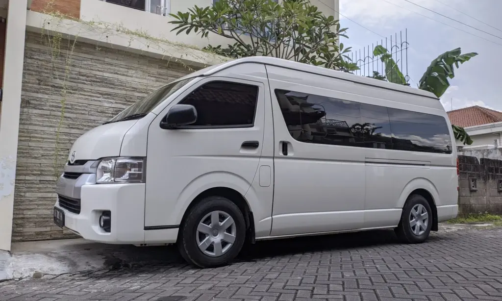 Travel van driving on an open road towards the mountains.